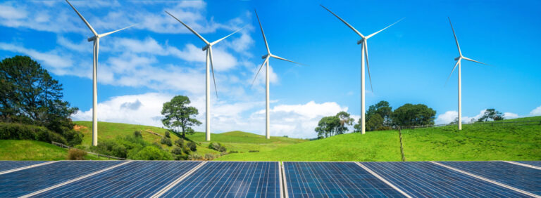 Solar panel and wind turbines farm on green hills.