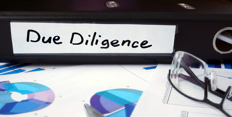 Graphs and file folder with label Due Diligence. Business concept.