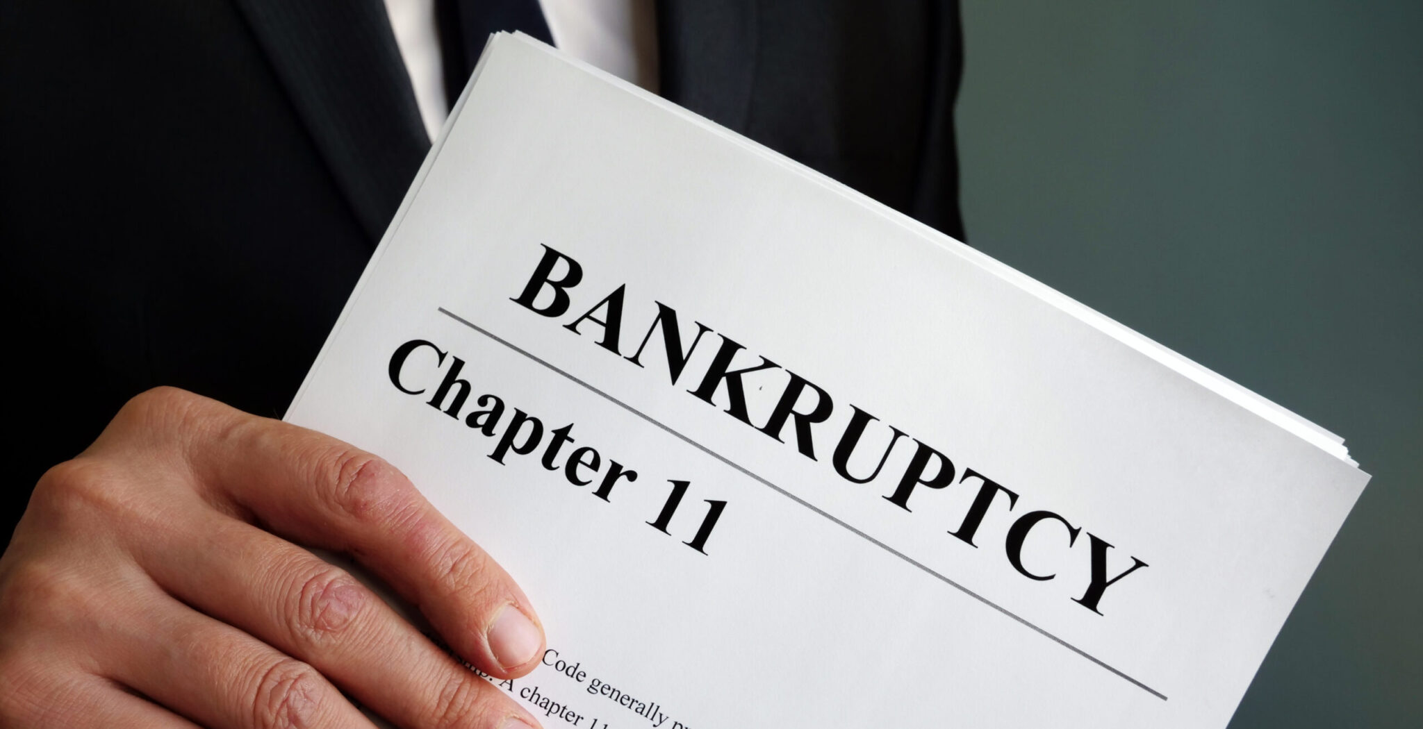 Man holds Bankruptcy Chapter 11 agreement documents.